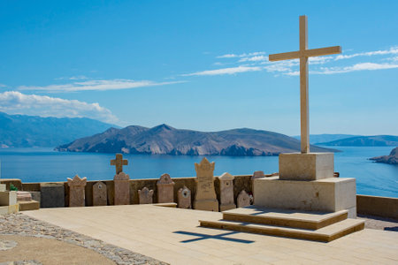 Baska, Croatia - 4th September 2021. Graves in the grounds of St John the Baptist Church on a hill above Baska, Krk island, Primorje-Gorski Kotar County, western Croatia. The island in the centre is Otok Prvicのeditorial素材