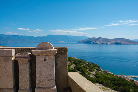 Baska, Croatia - 4th September 2021. Graves in the grounds of St John the Baptist Church on a hill above Baska, Krk island, Primorje-Gorski Kotar County, western Croatia. The island on the right is Otok Prvicのeditorial素材