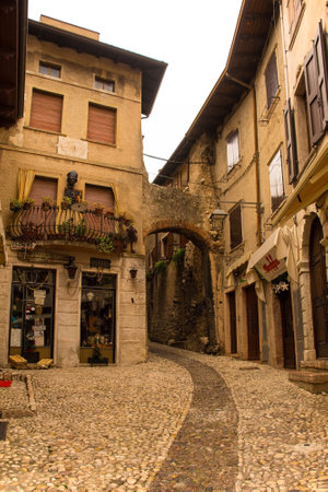 Malcesine, Italy - December 25th 2022. Christmas Day in the small town of Malcesine on the north shore of lake Garda, Verona Province, Veneto. The 6th century Siresina Gate is on the rightのeditorial素材