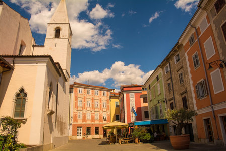Izola, Slovenia - 8th July 2022. A quiet square in the historic centre of Izola on the coast of Slovenia. The church of Saint Marije Alietske, also called Saint Mary of Alieto, is on the leftのeditorial素材