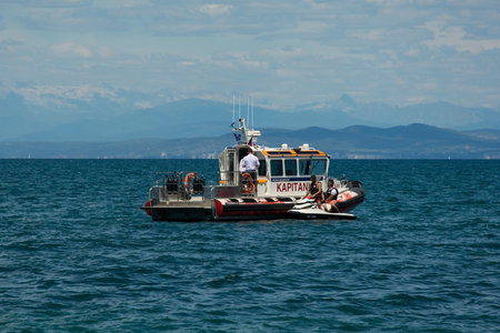 Izola, Slovenia - 9th July 2022. A coast guard boat intercepts a jet ski personal watercraft with 2...
