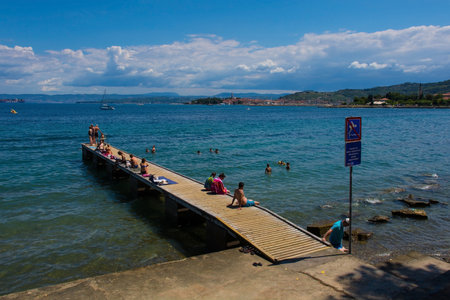 Izola, Sovenia - 10th July 2022. Locals and tourists enjoy the sun on the Adriatic coast of Slovenia near Izolaのeditorial素材