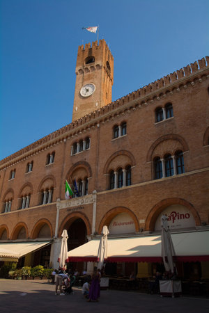 Treviso, Italy - 23rd July 2022. Civic Tower, Torre Civica, and the 13th century Palazzo del Podesta in Piazza dei Signori in the historic centre of Treviso, Veneto, north east Italy. It is now the seat of the Prefecture while the lower floors host restauのeditorial素材