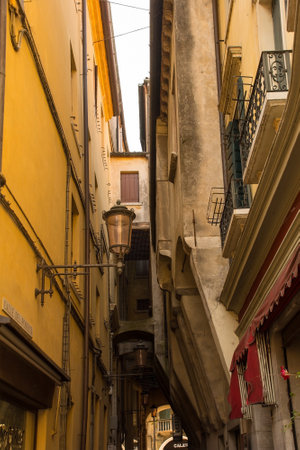 Treviso, Italy - 24th July 2022. The narrow medieval Calle del Podesta street showing arch supports for overhanging jettying on the right. In the historic centre of Treviso, Veneto, north east Italyのeditorial素材