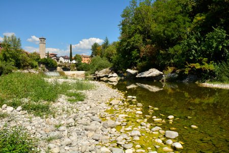 The Natisone river during the 2022 drought as it flows through the north east Italian town of Cividale del Friuli, Udine Province, Friuli-Venezia Giulia. Normally a popular swimming spot during the summer, it is deserted as the water is reduced to a trickle. August 14th 2022の写真素材