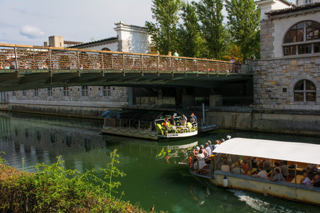 Ljubljana, Slovenia - September 3rd 2022. Tourist boats pass under Butchers Bridge crossing the Ljubljanici River in central Ljubljana, Slovenia. The bridge is known as Mesarski Most in Slovenian and is famous for its padlocksのeditorial素材
