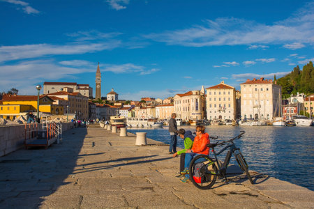 Piran, Slovenia - September 17th 2022. A pier at the waterfront of the historic medieval town of Piran on the coast of Slovenia. St George's Parish Church is background centreのeditorial素材