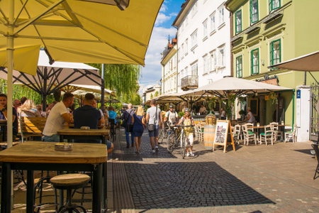 Ljubljana, Slovenia - September 4th 2022. A busy pedestrianised road with bars and restaurants on the waterfront of the Ljubljanici River in central Ljubljana, Slovenia, during the summer. Cankarjevo Nabrezje roadのeditorial素材