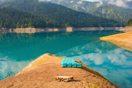 Low water in Sauris Lake, Lago di Sauris, in late September. The blue floats are where water normally is. The lake is artificial, formed by a dam, and is located in Udine Province, Friuli-Venezia Giulia, north east Italyの写真素材