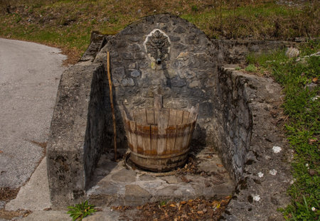 An old historic stone drinking water fountain in the village of Trava in Lauco district, Udine Province, Friuli-Venezia Giulia, north east Italyの写真素材