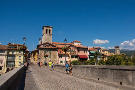 Cividale del Friuli, Italy - August 14th 2022. The historic Devil's Bridge - Ponte del Diavolo - over the Natisone river in Cividale del Friuli, north east Italy. The 15th century bridge was rebuilt in 1918. The tower is the Cathedral of Santa Maria Assunのeditorial素材