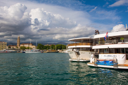 Split, Croatia - May 12th 2023. Boats for day trips and cruising in the harbour of the historic coastal town of Split in Dalmatia, Croatia. The Cathedral of Saint Domnius bell tower is background leftのeditorial素材