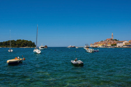 Boats on the historic waterfront of the medieval coastal town of Rovinj in Istria, Croatia. Otok Sveta Katarina, Saint Catherines Island, is on the left, and Saint Euphemia Church far rightの写真素材