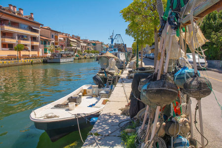 Grado, Italy - August 11th 2023. Fishing equipment and boats on the waterfront of Grado in Friuli-Venezia Giulia, north east Italyのeditorial素材