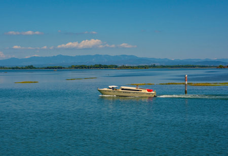 Grado, Italy - August 11th 2023. A water taxi crosses the shallow waters of the Grado section of the Marano and Grado Lagoon in Friuli-Venezia Giulia, north east Italyのeditorial素材