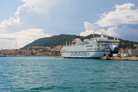 Split, Croatia - May 12th 2023. A roll-on/roll-off ferry going to nearby islands loads vehicles in the port of the historic coastal town of Split in Dalmatia, Croatia. Marjan Hill is in the backgroundのeditorial素材