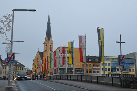 Villach, Austria - December 24th 2022. Christmas Eve on Draubrucke Bridge crossing the Drava River in the historical centre of Villach, Carinthia, Austria.  The spire of the church of Saint Nicholas is in the centre backgroundのeditorial素材