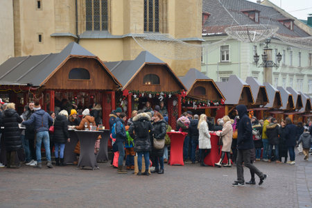 Villach, Austria - December 24th 2022. Christmas market stalls on Hauptplatz street on Christmas Eve in the historic centre of Villach in Carinthia, Austria. The parish church of Saint Jacob is in the backgroundのeditorial素材