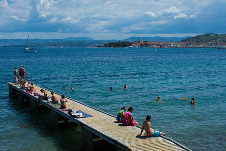 Izola, Sovenia - 10th July 2022. Locals and tourists enjoy the sun on the Adriatic coast of Slovenia near Izolaのeditorial素材