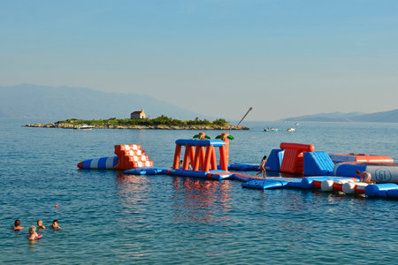 Novi Vinodolski, Croatia â September 11th 2023. An inflatable island playground in late summer at the city beach of Novi Vinodolski. San Marino Island n the background. Primorje-Gorski Kotar Countyのeditorial素材