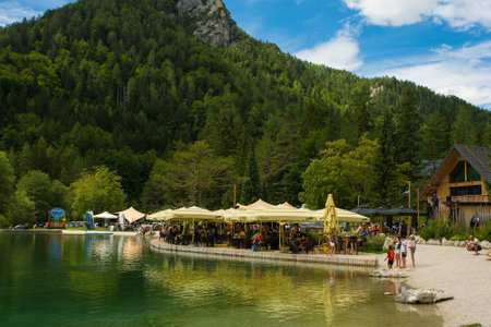 Kranjska Gora, Slovenia - August 21st 2022. Tourists enjoy food and drink at a bar on Jasna Lake near Kranjska Gora in the Upper Carniola region of north west Slovenia. An artificial lake created for tourism purposesのeditorial素材