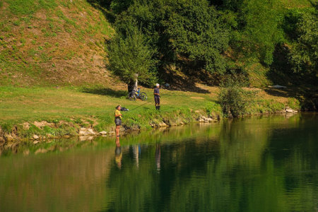 Srpske Toplice, Bosnia - September 5th 2023. Men fish in the Vrbas River as it flows through Srpske Toplice south east of Banja Luka in Republika Srpska, Bosnia and Herzegovina. Viewed at Vrucica Hot Springsのeditorial素材