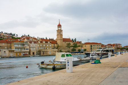 Sutivan, Croatia - May 14th 2023. The harbour of the historic village of Sutivan on Brac Island in Croatia. The Church of the Assumption of the Blessed Virgin Mary is centreのeditorial素材