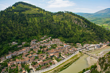 A view of the Gorica quarter of Berat in Albania taken from Berat Castle. Berat is UNESCO listed and is known as City of a Thousand Windows. In the background is Mali Partizan Mountain, and in the foreground the Osum river crossed by Gorica Bridgeの写真素材