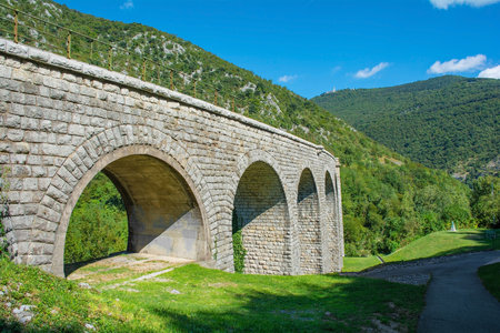 The Solkan Bridge over the Soca River at Solkan near Nova Gorica , Primorska, Slovenia. It is the longest stone arch railroad bridge in the world, and second longest stone arch bridge. Part of the Soca Valley karst landscape. Mount Sabotin in the backgroundの写真素材