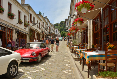 Gjirokaster, Albania - June 4th 2024. A car rally in Gjirokaster Bazaar, an historic marketplace known for its well-preserved Ottoman architecture. Narrow, cobbled streets lined with traditional stone buildings, shops selling local crafts, bars and restaurants. UNESCO World Heritage Site listedの写真素材