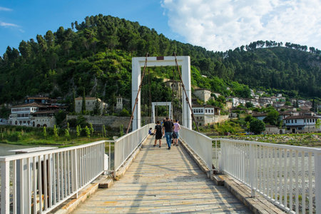 The White Bridge crossing Osum River from the Mangalem quarter to the Gorica quarter of Berat, Albania. Also called Hanging Bridge, completed 2015, it is a suspension bridge with two white towers. Berat is UNESCO listed and is known as City of a Thousand Windows. It is famous for its traditional Ottoman architecture. Mali Partizan Mountain is in the background. Ura e Bardheの写真素材