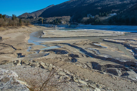 Lago di Barcis - Barcis artificial lake drained of water for routine maintenance, in Friuli-Venezia Giulia, north east Italy. The reservoir was created in 1954 for hydroelectric energy production. Located in Val Cellina in the Friulian Dolomites, it is normally a picturesque lake with emerald waters, and is a popular tourist attraction. Also known as Lake Aprilisの写真素材