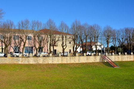 A sunken lawn next to the castle in the historic village of Svetvincenat in central Istria, Croatia. Traditional stone crenellated walls separate the road and buildings from the parkの写真素材