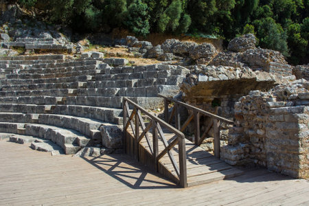 The 3rd century Roman Amphitheatre in Butrint Archaeological Park, within Butrint National Park, southern Albania. A UNESCO World Heritage Site. On the right of the Cavea seating area is a Parodos. One of the best-preserved monuments in Butrint. It could accommodate over 2,000 spectators and hosted dramatic performances, assemblies and gladiatorial gamesの写真素材