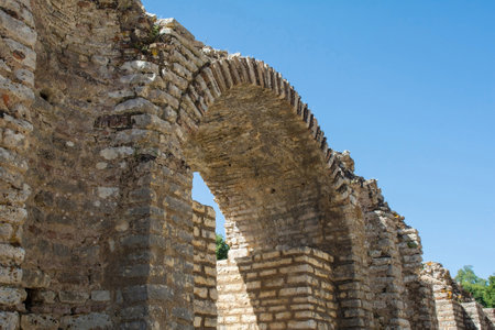 The arched entrance to the 3rd century Roman Amphitheatre in Butrint Archaeological Park, within Butrint National Park, southern Albania. A UNESCO World Heritage Site. One of the best-preserved monuments in Butrint. It could accommodate over 2,000 spectators and hosted dramatic performances, assemblies and gladiatorial gamesの写真素材