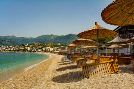 Straw umbrellas on Potam Beach at the southern end of Himare Bay on the coast of south Albania, part of the Albanian Riviera. Located in Vlore County, it lies between the Ceraunian Mountains and the Ionian Sea and is a major tourism centreの写真素材