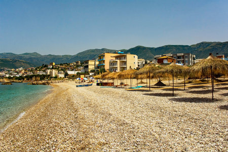 Straw umbrellas on Potam Beach at the southern end of Himare Bay on the coast of south Albania, part of the Albanian Riviera. Located in Vlore County, it lies between the Ceraunian Mountains and the Ionian Sea and is a major tourism centreの写真素材