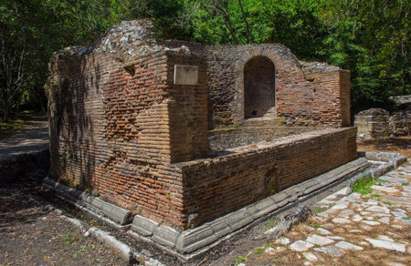 The Nymphaeum in Butrint Archaeological Park, within Butrint National Park, southern Albania. A UNESCO World Heritage Site. A 2nd century monumental Roman fountain formed by a semicircular pool facing east on the street leading to the Tower Gate, with a circular wall and 3 niches, of which the central one had a cloister vault & the lateral ones barrel vaults. Enclosed by a ditch. A public water feature, likely dedicated to nymphs and used for religious or decorative purposesの写真素材