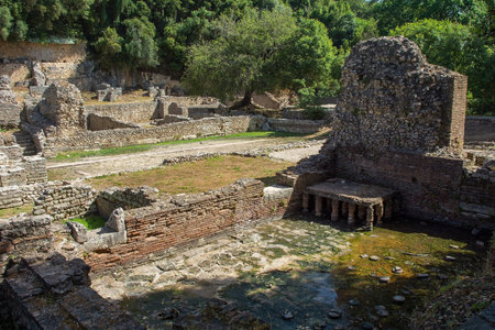 A Roman public bathhouse in Butrint Archaeological Park, within Butrint National Park, southern Albania. A UNESCO World Heritage Site. Located next to the Roman Forum, hypocaust heating allowed the circulation of warm air to heat baths, the brick pillars supported the floor. It featured a series of rooms for hot, warm and cold bathing (caldarium, tepidarium, frigidarium). The baths served as a social and recreational hubの写真素材