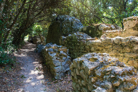 The ruins of walls near the Roman Forum in Butrint Archaeological Park, within Butrint National Park, southern Albania. A UNESCO World Heritage Site. This was Butrint's civic centre, surrounded by administrative and commercial buildings, and including a marketplace, temples and a basilicaの写真素材