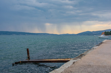 Stormy sky on the Adriatic coast of Croatia at Kastel Kambelovac in Kastela, with a rusted old...