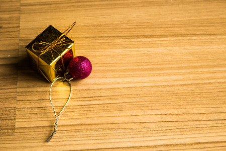 Color balls and gift box christmas left side on a wooden brown floor background.の写真素材