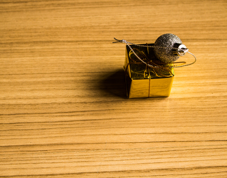 Color balls and gift box christmas right side on a wooden brown floor background.の写真素材