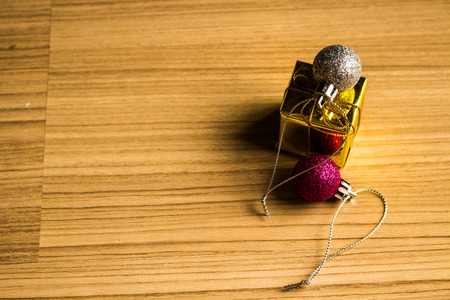 Color balls and gift box christmas right side on a wooden brown floor background.の写真素材