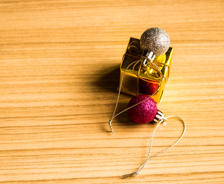 Color balls and gift box christmas right side on a wooden brown floor background.の写真素材