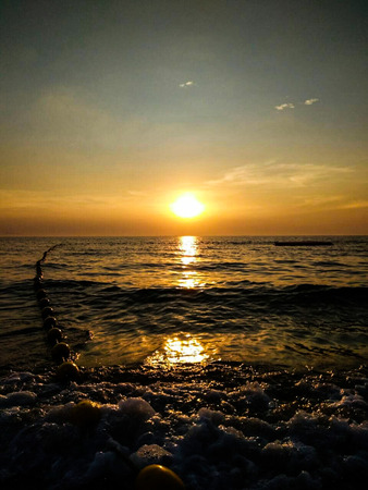 The sun was falling on the beach sea water.の写真素材