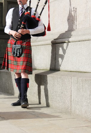 scottish man in kilt playing the bagpipes entertaining the crowdの写真素材