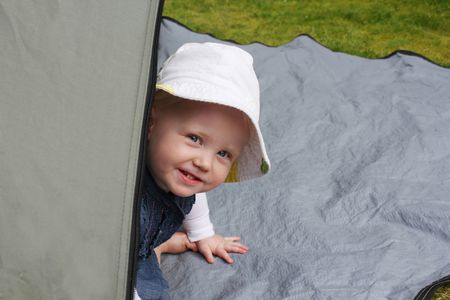 child peeking round tent door の写真素材