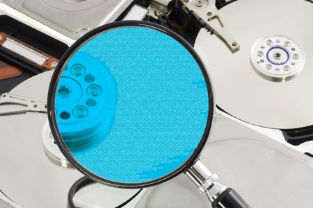 Magnifying glass over a opened hard drive depicting computer forensic