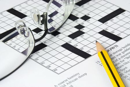 Pencil and spectacles on top of a crossword puzzleの写真素材